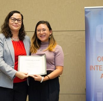 Michele Moy accepts the Everett and Florence Drumright award from Diplomat in Residence, Melisa Martinez.
                  