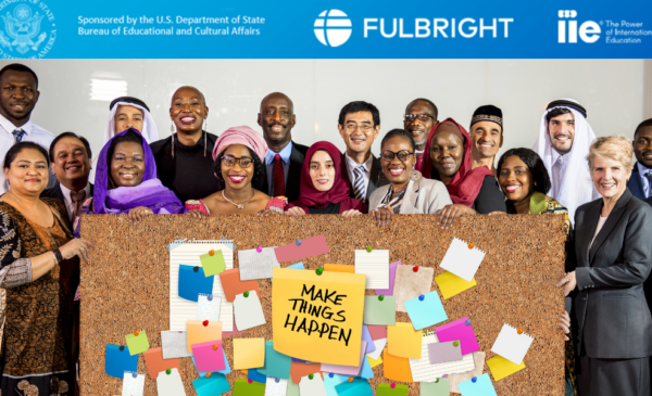 A group of international people standing under the Fulbright logo